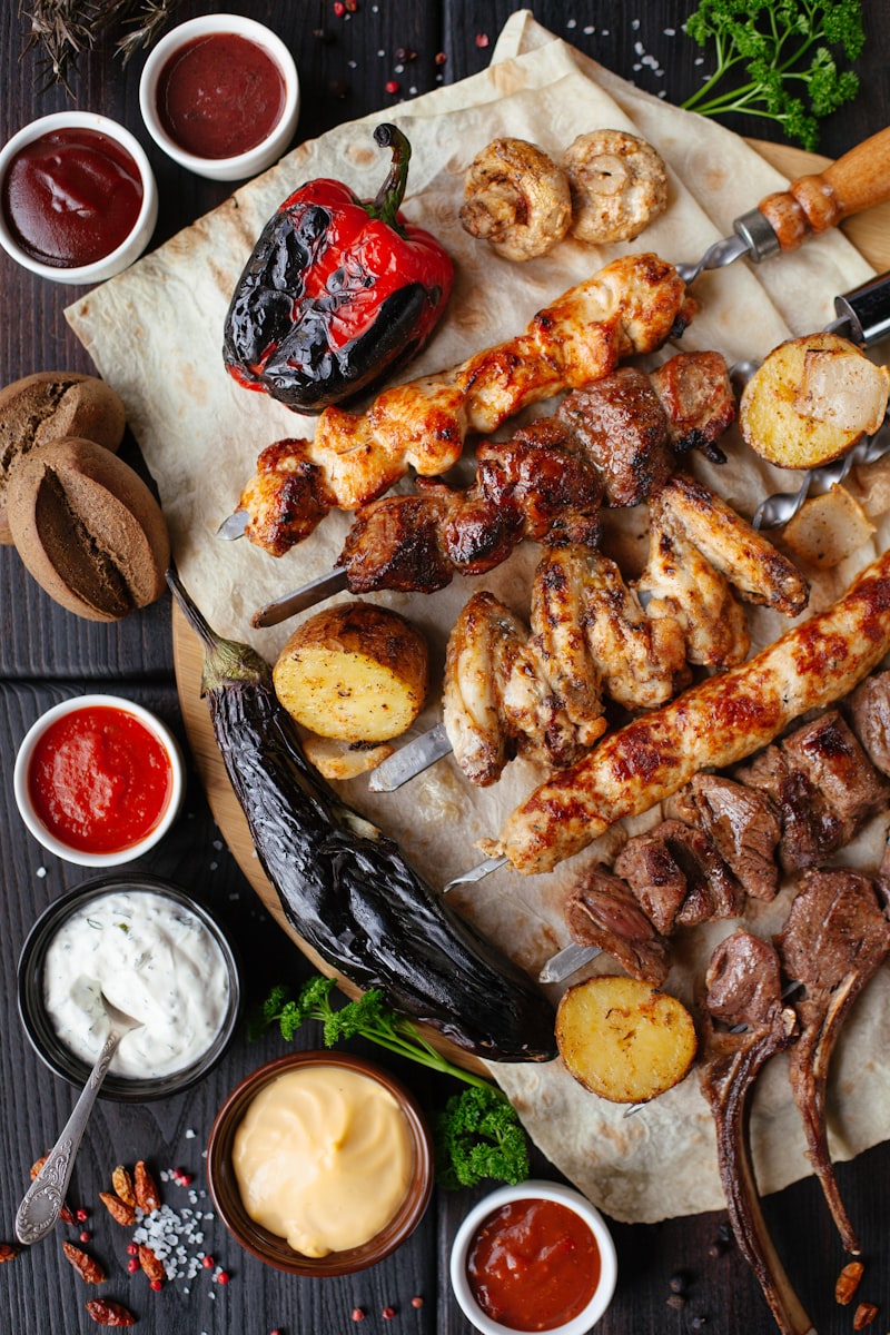 Espetada beef skewers grilling over charcoal on a bay-laurel branch
